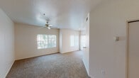 Located at 13700 N Fountain Hills Blvd in Fountain Hills, Arizona, this single-floor unit offers a well-organized and functional layout throughout. The spacious living area is finished with plush carpeting and features multiple windows that invite an abundance of natural light, complemented by a ceiling fan and a textured ceiling overhead. Vertical blinds on a sliding glass door provide access to an outdoor area, extending the living space beyond the interior walls. The kitchen is efficiently designed with ample cream-toned cabinetry offering generous storage, light-colored countertops, tile flooring, and appliances including an electric coil range and an over-the-range microwave. The bedrooms are carpeted and each includes a ceiling fan, with one room featuring direct outdoor access through a sliding glass door fitted with vertical blinds. The bathroom presents a clean, practical design with tile flooring, a vanity with a sink, mirrored cabinet storage, and convenient towel bar fixtures. Throughout the unit, the neutral color palette of warm beige tones creates a cohesive and inviting atmosphere, while the consistent presence of ceiling fans across rooms ensures year-round comfort in the Arizona climate.