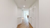 This well-appointed single-floor residence in San Diego's 92108 neighborhood offers a thoughtfully designed layout across three bedrooms and two full bathrooms. The open-concept kitchen and living area serves as the heart of the home, showcasing warm wood-grain cabinetry extending to the ceiling, a white quartz waterfall island, stainless steel appliances including a gas range and French door refrigerator, a white subway tile backsplash, and pendant lighting—all set on light hardwood flooring that flows throughout the main living spaces.

The bedrooms feature neutral carpet and large windows framing views of palm trees, surrounding greenery, and the San Diego hillside and cityscape, filling each room with natural light. The primary bedroom includes sliding closet doors and balcony access. Both bathrooms are finished in a clean, modern style with white subway-tiled tub-shower combinations, brushed nickel fixtures, light hardwood flooring, and warm wood cabinetry. Three hallways connect the rooms efficiently throughout the unit. The overall aesthetic is contemporary and cohesive, with a bright, neutral palette complemented by natural wood tones.