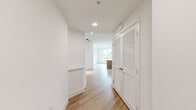 This well-appointed single-floor residence in San Diego's 92108 neighborhood offers a thoughtfully designed layout across three bedrooms and two full bathrooms. The open-concept kitchen and living area serves as the heart of the home, showcasing warm wood-grain cabinetry extending to the ceiling, a white quartz waterfall island, stainless steel appliances including a gas range and French door refrigerator, a white subway tile backsplash, and pendant lighting—all set on light hardwood flooring that flows throughout the main living spaces.

The bedrooms feature neutral carpet and large windows framing views of palm trees, surrounding greenery, and the San Diego hillside and cityscape, filling each room with natural light. The primary bedroom includes sliding closet doors and balcony access. Both bathrooms are finished in a clean, modern style with white subway-tiled tub-shower combinations, brushed nickel fixtures, light hardwood flooring, and warm wood cabinetry. Three hallways connect the rooms efficiently throughout the unit. The overall aesthetic is contemporary and cohesive, with a bright, neutral palette complemented by natural wood tones.