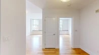 Located at 227 Church Street in the heart of New Haven, CT, this one-bedroom, one-bathroom apartment offers a well-designed layout with thoughtful finishes throughout. Warm hardwood flooring flows seamlessly across the living room, hallway, and bedroom, creating a bright and cohesive feel. The open-concept kitchen is a standout feature, anchored by a curved granite countertop peninsula with an integrated sink that opens directly to the living area — ideal for everyday functionality. Rich wood cabinetry, dark granite surfaces, and a full suite of stainless steel appliances, including a refrigerator, range, and microwave, complete the kitchen. The spacious bedroom offers a generous closet and large windows with city views, allowing ample natural light to fill the room. Additional windows with built-in sills are found throughout, further enhancing the bright, airy atmosphere. The bathroom features dark granite tile flooring, a tub-shower combination, and clean white fixtures. A welcoming entry hallway connects all areas of the unit efficiently. This apartment combines modern finishes with a practical floor plan in a prime New Haven location.