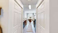 This thoughtfully designed one-bedroom, one-bathroom residence in Germantown, Tennessee offers a comfortable and cohesive layout across a single floor. The entrance leads into a galley-style kitchen featuring warm wood cabinetry, white countertops, black appliances, and light hardwood-style flooring that extends through the main living areas. The kitchen flows naturally toward a dedicated dining area bathed in natural light from multiple windows dressed with soft linen curtains, creating an inviting space for everyday meals. The living room serves as the heart of the home, highlighted by a tile-surround fireplace, large windows, and a ceiling fan, lending the room an airy and comfortable ambiance. The spacious primary bedroom is carpeted for warmth and comfort, featuring multiple windows with sheer curtains, a ceiling fan, and ample room for furnishings. The bathroom is conveniently accessible from the bedroom and includes a full tub and shower combination. A hallway connects the main areas of the unit efficiently, with closet storage thoughtfully integrated along the way. Throughout the residence, a neutral color palette, consistent flooring, and abundant natural light create a bright, welcoming atmosphere well-suited for comfortable everyday living.