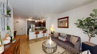 Located at 28850 Dixon St in Hayward, California, this two-bedroom, one-bathroom residence offers a thoughtfully designed single-floor layout. The modern kitchen is a standout feature, showcasing rich dark-walnut cabinetry, stainless steel appliances including a refrigerator, range, and microwave, and a sleek quartz peninsula countertop with bar seating — illuminated by stylish pendant lighting. Light wood-style flooring flows through the kitchen and living areas, creating a warm, cohesive aesthetic. The living room is bright and welcoming, benefiting from a large sliding glass door that invites natural light and provides outdoor access. The entry hallway adds a functional transition space. Both bedrooms feature plush carpeting and ample natural light from well-positioned windows, with the primary bedroom offering generous proportions and a spacious closet with sliding panel doors. The full bathroom is well-appointed with dark wood cabinetry, a granite-style vanity, a soaking tub with shower, and wood-look tile flooring. Clean white walls throughout the residence provide a neutral backdrop, while recessed lighting ensures a bright and inviting atmosphere in every room.