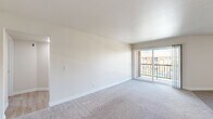 Located at 17730 Lassen St in the Northridge neighborhood of Los Angeles, this well-appointed 2-bedroom, 3-bathroom residence offers a comfortable and functional single-floor layout. The living area is bright and open, featuring plush carpeting and a large sliding glass door that opens to a private balcony, inviting ample natural light and outdoor views. The kitchen is outfitted with white cabinetry, speckled quartz-style countertops, a gas range, and an over-the-range microwave, providing a clean and efficient cooking space. Both bedrooms are generously sized and carpeted, offering a cozy atmosphere. The primary bedroom includes mirrored sliding closet doors, adding a sense of depth and storage convenience. The bathrooms are finished with light wood-style vinyl flooring, white vanities with stone countertops, and a shower-tub combination, maintaining a clean and cohesive aesthetic throughout. Two hallways connect the rooms efficiently, contributing to a smooth and practical flow. The neutral color palette of whites and soft beiges used throughout the space creates a bright, airy ambiance that is easy to personalize.