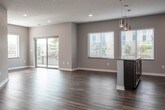 This single-floor residence is thoughtfully designed with a contemporary aesthetic and functional layout. The open-concept living and dining area flows seamlessly into the kitchen, creating a spacious, connected environment ideal for everyday living. Recessed lighting and multiple windows with horizontal blinds allow generous natural light throughout, while a sliding glass door leads to a private balcony overlooking the outdoors.

The kitchen is a standout feature, equipped with rich dark espresso cabinetry, granite countertops, a decorative penny-tile backsplash, and a full suite of stainless steel appliances including a range, microwave, dishwasher, and refrigerator. A granite-topped island with pendant lighting adds both workspace and visual appeal.

Hardwood-style flooring extends throughout the main living areas, while the bedrooms feature plush carpeting and ceiling fans. At least one bedroom includes a walk-in closet with wrap-around shelving and hanging rods, offering ample storage. A dedicated laundry area with stacked washer and dryer hookups is conveniently accessible from the bedroom.

The bathroom is clean and functional, featuring a full tub and shower combination, granite-topped vanity with dark cabinetry, and hardwood-style flooring consistent with the rest of the home.