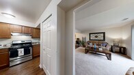 Located at 1820 Wessel Ct in St. Charles, IL, this well-designed 2-bedroom, 1-bathroom residence offers a thoughtfully laid-out single-floor plan. The living room serves as the heart of the home, featuring plush carpeting, neutral-toned walls, and a large sliding glass door that floods the space with natural light and opens to a private balcony overlooking lush, mature trees. The kitchen is equipped with warm wood cabinetry, granite-style countertops, stainless steel appliances including a refrigerator and dishwasher, and durable hardwood-style flooring. The spacious primary bedroom features carpeted floors, a wide window with outdoor views, and its own private sliding door access to a second balcony, offering a tranquil retreat. The second bedroom is a cozy, carpeted space with ample room for furnishings. Both bedrooms benefit from good closet storage. The full bathroom is finished with tile flooring, a wood-toned vanity, and a full tub-shower combination. A connecting hallway links all rooms efficiently. The outdoor balconies provide peaceful views of the surrounding greenery, enhancing the overall sense of calm and connection to nature throughout this inviting residence.