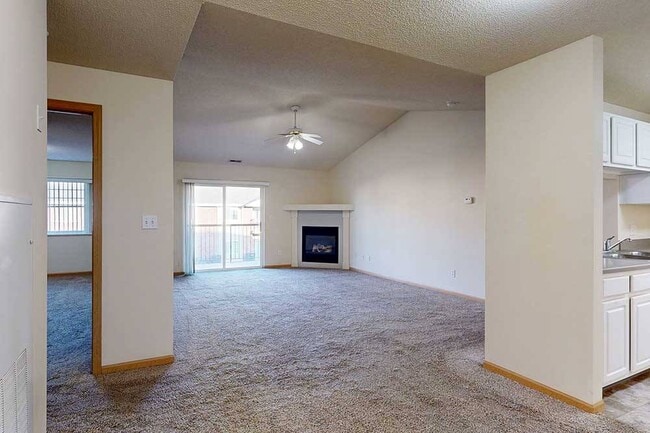 Spacious living and dining areas flow together effortlessly, creating a warm and welcoming space for everyday living or entertaining by the fire. - Northbrook Apartments