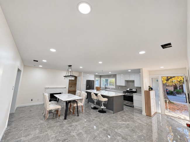 Cocina remodelada con una gran isla central, gabinetes modernos y electrodomésticos de acero inoxidable. - 826 San Pablo Ave