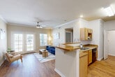 Located at 301 Lakeshore Blvd N in Slidell, Louisiana, this well-appointed 2-bedroom, 2-bathroom single-floor residence offers a comfortable and functional layout. The open-concept living, dining, and kitchen area serves as the heart of the home, highlighted by warm hardwood-style flooring, crown molding, and a ceiling fan. French doors flood the living room with natural light and provide access to the private patio. The kitchen features light wood cabinetry, granite-tone countertops, a breakfast bar peninsula, a double-basin sink, and black appliances including a range and dishwasher. A pantry provides additional storage. The dining area offers a defined space with hardwood-style flooring and crown molding. The spacious primary bedroom connects to a full bathroom with wood-tone cabinetry and a dedicated closet. The second bedroom is carpeted and includes its own closet. Three closets total provide ample storage throughout the unit. A dedicated in-unit laundry area with washer and dryer hookups adds everyday convenience. Two hallways connect the living spaces to the bedrooms and bathrooms seamlessly. The residence also includes on-site parking, rounding out a practical and inviting living experience.
