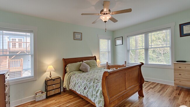 Dormitorio principal con ventilador de techo y baño privado. - 144 Estelle Park Dr