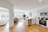 Located at 115 Main Street in Lincoln Park, NJ, this well-appointed one-bedroom, one-bathroom residence offers a bright and efficient layout designed for comfortable everyday living. Warm hardwood-style flooring flows throughout the entire space, unifying each room with a clean, cohesive aesthetic.

The open-concept living, dining, and kitchen area forms the heart of the home. The kitchen is outfitted with white shaker cabinetry, quartz countertops, a white subway tile backsplash, stainless steel appliances including a refrigerator, range, microwave, and dishwasher, and a pendant light over the sink. The living area is generously proportioned, bathed in natural light from large windows with blinds, and offers ample room for seating and dining furniture.

The bedroom is a comfortable retreat featuring a large window that invites natural light, a double-door closet, and a second closet for additional storage. A dedicated laundry area adds everyday convenience. The bathroom features a walk-in glass shower with large-format neutral tiles and chrome fixtures, delivering a clean, modern finish. Throughout the residence, a soft, neutral color palette and abundant natural light create a calm and inviting atmosphere.