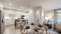 This thoughtfully designed single-story residence offers a seamless blend of comfort and contemporary style across a well-utilized floor plan. The open-concept kitchen and dining area serve as the heart of the home, featuring crisp white cabinetry, a subway tile backsplash, stainless steel appliances, and a central island with bar seating — all set atop light-toned hardwood-style flooring that enhances the bright, airy atmosphere.

The living room offers a welcoming retreat with neutral tones, hardwood-style flooring, and French doors that invite abundant natural light and outdoor views. The spacious bedroom is carpeted for warmth and comfort, with large windows that brighten the room and a ceiling fan overhead. It is accompanied by a generously sized walk-in closet outfitted with dual hanging rods and built-in shelving for organized storage.

The two bathrooms are finished with granite countertops, white cabinetry, and a tub-shower combination. A dedicated office space provides a quiet work area with its own window and carpet flooring, making it ideal for remote work or study. Throughout the residence, a cohesive neutral color palette, recessed lighting, and ceiling fans contribute to a clean, modern aesthetic.