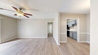 Located at 220 Edgewood Terrace Dr in Jackson, MS, this well-appointed one-bedroom, two-bathroom unit offers a thoughtful single-floor layout designed for comfortable everyday living. The open living area greets you with light wood-style flooring, neutral warm-toned walls, a textured ceiling, and a ceiling fan that enhances air circulation. Large sliding glass doors flood the space with natural light while providing outdoor views. The layout flows naturally into the dining area, which features a classic pendant light fixture, chair-rail molding detail, and the same hardwood-style flooring, with direct sightlines into the kitchen. The kitchen is outfitted with stylish gray cabinetry, brushed nickel hardware, light quartz-style countertops, a stainless refrigerator, and black appliances — offering both function and contemporary appeal. A hallway connects the living spaces to the private bedroom, which features plush wall-to-wall carpet, a ceiling fan with light, a large window for natural light, and a double-door built-in closet providing ample storage. Two bathrooms serve the unit, including one with a full tub-shower combination with white tile surround and another with a wide vanity counter, under-mount sink, and large mirror. Clean finishes and a neutral palette throughout give the space a cohesive, move-in-ready feel.