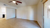 Located at 960 N Gilbert Rd in Gilbert, AZ, this single-story 2-bedroom, 1-bathroom unit offers a functional and well-organized layout. Light wood-style flooring runs throughout the space, providing a clean, cohesive look. The open living room is bright and airy, featuring a ceiling fan with light kit, textured ceilings, and a sliding glass door that fills the room with natural light and opens to an outdoor patio area. The galley-style kitchen is efficiently designed with white upper and lower cabinetry, light countertops, a stainless steel sink, and black appliances including a refrigerator, range, and dishwasher. A dedicated closet area houses a stacked washer and dryer, adding everyday convenience. The primary bedroom is generously sized, with a ceiling fan, a window with vertical blinds, and direct access to the full bathroom. The second bedroom is a comfortable size, also featuring a window that brings in natural light. The full bathroom includes a single-sink vanity with white cabinetry and a tub/shower combination. Throughout the unit, neutral wall tones and clean finishes create a bright, move-in ready atmosphere well-suited for comfortable living in the Gilbert area.