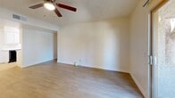 Located at 960 N Gilbert Rd in Gilbert, AZ, this single-story 2-bedroom, 1-bathroom unit offers a functional and well-organized layout. Light wood-style flooring runs throughout the space, providing a clean, cohesive look. The open living room is bright and airy, featuring a ceiling fan with light kit, textured ceilings, and a sliding glass door that fills the room with natural light and opens to an outdoor patio area. The galley-style kitchen is efficiently designed with white upper and lower cabinetry, light countertops, a stainless steel sink, and black appliances including a refrigerator, range, and dishwasher. A dedicated closet area houses a stacked washer and dryer, adding everyday convenience. The primary bedroom is generously sized, with a ceiling fan, a window with vertical blinds, and direct access to the full bathroom. The second bedroom is a comfortable size, also featuring a window that brings in natural light. The full bathroom includes a single-sink vanity with white cabinetry and a tub/shower combination. Throughout the unit, neutral wall tones and clean finishes create a bright, move-in ready atmosphere well-suited for comfortable living in the Gilbert area.