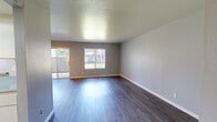 Located at 4433 Continental Way in Stockton, California, this single-floor, one-bedroom, one-bathroom unit offers a practical and well-organized layout across a comfortable footprint. The interior is finished with wood-style laminate flooring throughout, complementing the neutral gray walls and white trim that give the space a clean, modern feel.

The unit features two living areas, one of which includes a ceiling fan with integrated lighting, a pass-through window connecting to the kitchen, and a sliding glass door that brings in natural light. The second living area is open and bright, with windows overlooking the exterior.

The kitchen is laid out in a galley style, with white cabinetry, laminate countertops on both sides, and essential appliances including a range and dishwasher. Its efficient design maximizes functionality within a compact space.

The bedroom is a well-proportioned room featuring wood-style flooring, a window for natural light, and neutral walls, offering a calm and restful environment.

The bathroom includes a full tub-shower combination with a curtain rod, a vanity with a gray countertop, and wood-style flooring, all finished in a clean, understated palette.

Overall, the unit presents a consistent, move-in-ready aesthetic with practical features throughout.