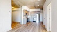 Located at 770 Somerset St W in Ottawa's vibrant Centretown neighbourhood, this modern 2-bedroom, 2-bathroom unit showcases an industrial-chic aesthetic defined by striking exposed concrete ceilings and warm light hardwood flooring throughout. The open-concept living, dining, and kitchen area forms the heart of the unit, creating a seamless and functional layout. The kitchen is well-appointed with sleek taupe cabinetry extending to the ceiling, a white tile backsplash, stainless steel appliances including a built-in oven, microwave, dishwasher, and refrigerator, and generous counter space. Track lighting and exposed ductwork add to the contemporary industrial character. The two bedrooms offer a quiet retreat, each featuring natural light from large windows with roller blinds and continued hardwood flooring. The primary bedroom includes a built-in closet with sliding doors, while raw concrete columns provide a bold architectural accent. Both bathrooms are finished with large-format tile flooring, modern vanities, and clean, understated fixtures. Additional spaces include a den, laundry room, and multiple closets for ample storage. The unit also benefits from an in-suite laundry and is ideally positioned near shops, transit, and dining along Somerset Street West.