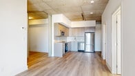 Located at 770 Somerset St W in Ottawa's vibrant Centretown neighbourhood, this modern 2-bedroom, 2-bathroom unit showcases an industrial-chic aesthetic defined by striking exposed concrete ceilings and warm light hardwood flooring throughout. The open-concept living, dining, and kitchen area forms the heart of the unit, creating a seamless and functional layout. The kitchen is well-appointed with sleek taupe cabinetry extending to the ceiling, a white tile backsplash, stainless steel appliances including a built-in oven, microwave, dishwasher, and refrigerator, and generous counter space. Track lighting and exposed ductwork add to the contemporary industrial character. The two bedrooms offer a quiet retreat, each featuring natural light from large windows with roller blinds and continued hardwood flooring. The primary bedroom includes a built-in closet with sliding doors, while raw concrete columns provide a bold architectural accent. Both bathrooms are finished with large-format tile flooring, modern vanities, and clean, understated fixtures. Additional spaces include a den, laundry room, and multiple closets for ample storage. The unit also benefits from an in-suite laundry and is ideally positioned near shops, transit, and dining along Somerset Street West.