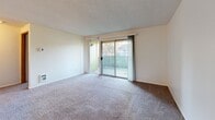Located at 11716 NE 49th St in Vancouver, WA, this 2-bedroom, 1-bathroom single-floor unit offers a practical and comfortable layout across a well-utilized footprint. The living room is a bright, open space finished with neutral carpet and a textured ceiling, and features a sliding glass door that opens to a private outdoor balcony, allowing natural light and outdoor views to flow into the room. A wall-mounted thermostat and a floor-level heating vent are present throughout the unit for climate control.

The kitchen is finished with light wood-style vinyl flooring and features white cabinetry, gray laminate countertops, a window above the sink, and white appliances including a dishwasher, range, and refrigerator — providing a clean and functional cooking space.

Both bedrooms are carpeted with textured ceilings and include sliding wood-panel closet doors, offering generous storage. The primary bedroom connects conveniently to the full bathroom, which features light wood-style vinyl flooring, a single-sink vanity with storage drawers, a toilet, and a tub-shower combination.

Additional highlights include a dedicated laundry area, a hallway connecting the main living spaces, and four closets throughout the unit, maximizing storage options across the floor plan.