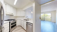 Located at 6929 Kester Ave in Van Nuys, Los Angeles, this single-floor unit offers a clean, functional layout designed for comfortable everyday living. The open-concept kitchen and living area form the heart of the space, unified by light wood-look flooring and crisp white vertical shiplap wall paneling that lends a cohesive, modern-classic character throughout.

The kitchen is well-appointed with white cabinetry providing ample storage, light-toned countertops, and a full suite of stainless steel appliances, including a double-oven gas range, a built-in dishwasher, and a French door refrigerator. A double basin sink with a modern faucet sits beneath an overhead cabinet setup, making the kitchen both practical and visually clean.

The living area is generously proportioned and bathed in natural light, thanks to a large sliding glass door that opens to an outdoor view of lush greenery. A ceiling fan overhead adds to the airy atmosphere. The textured ceiling adds a subtle design detail that contrasts pleasingly with the smooth walls.

The bathroom continues the space's light and neutral palette, featuring a vanity with white cabinetry, a tub-shower combination, and the same wood-look flooring found throughout. The overall ambiance of this unit is bright, clean, and inviting, making it a well-organized and efficiently designed space in the heart of Los Angeles.
