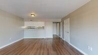 Located at Watermark Place in Columbia, SC, this two-story, two-bedroom, two-bathroom home offers a practical and comfortable layout spread across two floors. The main level opens into a generous living room featuring warm hardwood-style flooring, neutral gray walls, and clean white trim. A half-wall peninsula seamlessly connects the living area to the kitchen, which is outfitted with white cabinetry, black appliances including a refrigerator, electric range, and dishwasher, as well as a single-basin sink beneath a window. Sliding glass doors in the living area lead to an outdoor balcony, allowing natural light to fill the space and offering views of the surrounding greenery. The upper level houses both bedrooms, each featuring plush carpeting, neutral tones, and ample closet space with bifold doors. The spacious primary bedroom provides a comfortable retreat, while the second bedroom is equally well-appointed. Two full bathrooms serve the home, each equipped with a tub-shower combination. A textured ceiling is noted in portions of the home, adding subtle character. With a staircase connecting the two floors, this well-laid-out home provides a functional flow throughout.