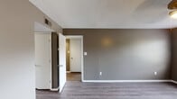 Located at 200 N Hills St in Meridian, Mississippi, this single-floor residence offers a cohesive and practical layout designed for comfortable everyday living. Throughout the home, warm taupe-toned walls are paired with crisp white trim and textured ceilings, creating a consistent and neutral aesthetic.

The living areas feature durable wood-look vinyl plank flooring and ceiling fans with integrated lighting, contributing to a bright and functional atmosphere. Natural light filters in through windows fitted with blinds, enhancing the open feel of the main rooms.

The kitchen is well-appointed with white cabinetry providing ample storage, light-colored countertops, and a full suite of stainless steel appliances including a range with oven, over-the-range microwave, refrigerator, and dishwasher. A double-basin sink is positioned beneath a window, and the kitchen's L-shaped layout allows for efficient use of the space.

The bedrooms are carpeted for added comfort and each includes a ceiling fan with light fixture. At least one bedroom features a sliding-door closet with built-in shelving. The bathroom is cleanly finished with wood-look vinyl flooring, a white vanity with a light countertop, and a full tub-shower combination with a curved curtain rod. The overall design prioritizes functionality with a clean, move-in ready presentation.