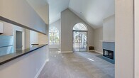 Located at 1600 Whitewood Ct in San Jose, CA, this single-floor, 2-bedroom, 2-bathroom residence offers a thoughtfully designed layout with standout architectural details. The living room is the centerpiece of the home, boasting dramatic vaulted ceilings that soar to impressive heights, arched windows that flood the space with natural light, and a stylish corner fireplace with a clean white mantel and modern surround. Sliding glass doors open to an outdoor balcony, bringing in views of mature trees and extending the living space beyond its walls. The kitchen features white cabinetry, dark countertops, a tile backsplash, and stainless steel appliances including a refrigerator, dishwasher, and range. A pass-through window connects the kitchen to the living area, enhancing the open feel. Both bedrooms are carpeted and well-lit by multiple windows with outdoor views, offering a calm and comfortable retreat. The two bathrooms are finished with wood-look flooring, white vanity cabinetry, dark countertops, large mirrors, and full bathtub/shower combinations. Two closets provide ample storage throughout. Neutral tones and consistent finishes give the home a cohesive, move-in-ready character.