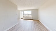 Located at 121 Minerva Ave in Toronto's Scarborough neighbourhood, this well-appointed 3-bedroom, 1-bathroom unit offers a thoughtfully designed single-floor layout. Light wood laminate flooring runs consistently throughout, lending a clean, cohesive look to the entire space.

The open-concept kitchen and living area form the heart of the unit. The kitchen features white cabinetry with gold-toned hardware, white appliances including a Frigidaire refrigerator and electric range, a white quartz countertop with an undermount sink, and a white tile backsplash. The adjacent living room is bright and open, with a large window and sliding door providing access to the private balcony and sweeping outdoor views.

The spacious primary bedroom includes a sliding door closet and views of the surrounding greenery. The two additional bedrooms are well-sized, each featuring windows with natural light and panel radiators for heating. One bedroom includes a dedicated walk-in closet.

The bathroom is finished in a clean, modern style with a white vanity, mirrored medicine cabinet, a tub-shower combination, and wood-look flooring. Additional storage is provided via a separate closet. The unit's neutral palette and updated finishes create a bright, move-in-ready environment.