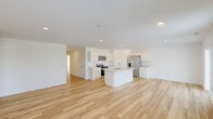 Located at 3782 Thunderhawk Pass in Fort Wayne, Indiana, this single-story, 3-bedroom, 2-bathroom home offers a clean, modern design with a bright and open feel throughout. Light-toned hardwood-style flooring runs continuously through the main living areas and bedrooms, complementing the crisp white walls and recessed lighting that keep every room feeling fresh and well-lit.

The heart of the home is a spacious open-concept area combining the kitchen, dining, and living spaces. The kitchen is outfitted with white shaker-style cabinetry, light countertops, stainless steel appliances including a refrigerator with ice maker, built-in microwave, and range, and a central island with a sink — ideal for both cooking and casual dining. A pantry provides additional storage. Sliding glass doors from the living area open to a patio with views of the surrounding neighborhood.

The primary bedroom is generously sized, with its own closet space. Two additional bedrooms offer versatility for guests, a home office, or family use. Six closets throughout the home ensure ample storage. Both bathrooms feature white vanities and tub-shower combinations with light flooring. A dedicated laundry room includes a full-size washer and dryer. The attached garage is spacious and finished with drywall and an automatic opener.