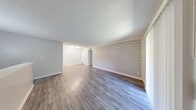 Located at 7920 S Sheridan Rd in Tulsa, Oklahoma, this one-bedroom, one-bathroom unit offers a well-organized single-floor layout designed for comfortable everyday living. The open-concept living room serves as the heart of the space, highlighted by a striking shiplap accent wall that adds a modern farmhouse character. Durable wood-look vinyl plank flooring runs throughout the main living areas, complemented by a textured ceiling and neutral gray tones that create a clean, cohesive aesthetic. A sliding glass door with vertical blinds floods the living room with natural light and provides direct access to an outdoor patio area with green views. The galley-style kitchen is efficiently designed with white cabinetry, light countertops, a deep single-basin sink with a matte black faucet, and black appliances including a range and refrigerator. The bedroom offers a comfortable footprint with plush carpeting, a textured ceiling, a closet, and a window that brings in additional natural light. The full bathroom features a tiled tub-shower combination, wood-look flooring, and classic white fixtures. A dedicated closet provides additional storage, rounding out this practical and well-appointed residence.