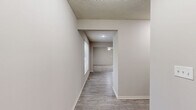 Located at 13025 Nebraska Ct in Kansas City, KS, this three-bedroom, four-bathroom home is thoughtfully arranged across three floors. The lowest level features an unfinished basement divided into two sections, offering generous utility and storage space, including a dedicated water heater area with exposed concrete walls and structural framing overhead. An attached garage with a concrete floor and automatic opener provides convenient vehicle storage.

The main floor combines the kitchen and living room into a cohesive open layout. The kitchen is outfitted with light wood cabinetry, a full suite of black appliances including a refrigerator, dishwasher, and microwave, and durable wood-look flooring. The living room is bright and airy, featuring soft carpeting, a ceiling fan with light fixture, and windows that invite natural light. A wood-railed staircase connects the floors with classic appeal.

The upper floor houses the three bedrooms, each carpeted and equipped with ceiling fans and windows providing natural light. The spacious primary bedroom includes closet access and an en-suite bathroom. The four bathrooms throughout the home are clean and functional, with tile flooring, vanities, and sliding-door enclosed showers. Two closets and two hallways further enhance the home's practical layout.