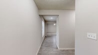 Located at 13025 Nebraska Ct in Kansas City, KS, this three-bedroom, four-bathroom home is thoughtfully arranged across three floors. The lowest level features an unfinished basement divided into two sections, offering generous utility and storage space, including a dedicated water heater area with exposed concrete walls and structural framing overhead. An attached garage with a concrete floor and automatic opener provides convenient vehicle storage.

The main floor combines the kitchen and living room into a cohesive open layout. The kitchen is outfitted with light wood cabinetry, a full suite of black appliances including a refrigerator, dishwasher, and microwave, and durable wood-look flooring. The living room is bright and airy, featuring soft carpeting, a ceiling fan with light fixture, and windows that invite natural light. A wood-railed staircase connects the floors with classic appeal.

The upper floor houses the three bedrooms, each carpeted and equipped with ceiling fans and windows providing natural light. The spacious primary bedroom includes closet access and an en-suite bathroom. The four bathrooms throughout the home are clean and functional, with tile flooring, vanities, and sliding-door enclosed showers. Two closets and two hallways further enhance the home's practical layout.