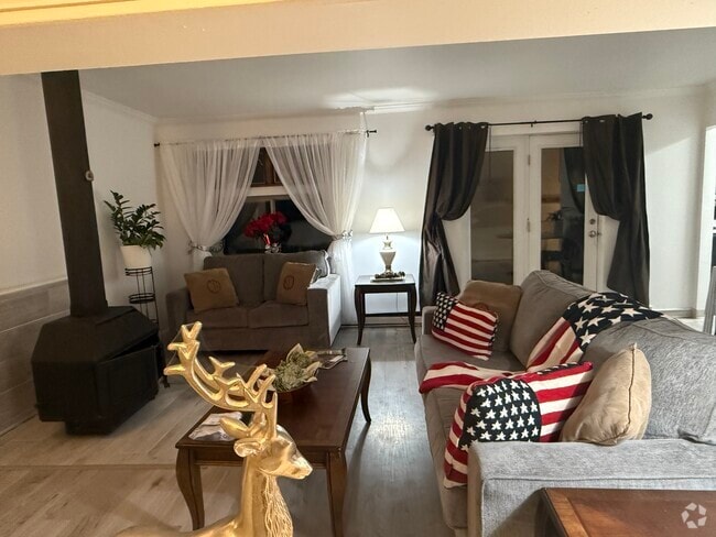 Living area with wood stove burning fireplace. - 1053 Danby Rd