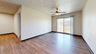 Located at 6055 S 11th Ave in Phoenix, Arizona, this one-bedroom, one-bathroom unit offers a well-designed single-floor layout with a cohesive, modern aesthetic throughout. Wood-look plank flooring runs seamlessly through every room, complemented by neutral-toned walls and dark baseboards that create a clean, contemporary look.

The open-concept kitchen and living area serves as the heart of the unit. The kitchen is equipped with rich dark-brown cabinetry offering ample storage, stone-patterned countertops, a double-basin stainless steel sink, and black appliances including a refrigerator, electric range, and microwave. A peninsula counter provides a natural transition into the living area.

The living room is bright and airy, benefiting from a ceiling fan with built-in light and a sliding glass door that opens to a private balcony with outdoor views — allowing natural light to fill the space throughout the day.

The bedroom is a comfortable, well-proportioned room featuring its own ceiling fan, a window with blinds for natural light and privacy, and easy access to the full bathroom. The bathroom includes wood-look flooring, a combination tub and shower, a vanity with dark cabinetry, and clean white finishes throughout. The overall layout is functional and efficient, ideal for comfortable single-occupant living.