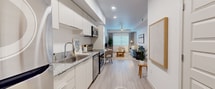 Step into a world where luxury meets functionality in this exquisitely crafted 670 square foot apartment. The heart of this home is a stunning kitchen that will inspire your inner chef. Sleek, white cabinetry stretches to the ceiling, maximizing storage and creating a sense of spaciousness. Stainless steel appliances, including a built-in microwave and state-of-the-art range, add a touch of sophistication while promising culinary adventures.

The living area is a testament to modern design, with its airy ambiance and carefully curated furnishings. Large windows invite natural light, creating a bright and welcoming atmosphere. The space seamlessly blends comfort and style, featuring a plush sofa, elegant coffee table, and tasteful decor that sets the stage for both relaxation and entertaining.

The bedroom is a serene retreat, boasting 150 square feet of pure comfort. A sumptuous bed takes center stage, promising restful nights and lazy mornings. The room's neutral palette and soft textures create a calming environment, while thoughtful touches like bedside tables and ambient lighting add to its allure.

The bathroom is a spa-like sanctuary, featuring a sleek glass-enclosed shower with built-in shelving for your toiletries. Its clean lines and modern fixtures exude luxury and offer a refreshing start to your day.

This home is not just about aesthetics; it's designed for easy living. A dedicated laundry area, ample closet space, and gleaming wood-look floors throughout make daily life a breeze. The attention to detail is evident in every corner, from the stylish ceiling fan to the carefully chosen artwork adorning the walls.

Located in the vibrant heart of Phoenix, this apartment offers the perfect blend of urban convenience and personal sanctuary. It's more than just a living space – it's an invitation to elevate your lifestyle and embrace the very best of modern, sophisticated living.