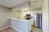 Located at 4900 Heather Dr in Dearborn, MI, this two-story, two-bedroom, two-bathroom home offers a well-organized layout spread across two floors. The main level features an open-concept living and kitchen area anchored by a fireplace with tile surround and durable wood-look flooring throughout. The kitchen is equipped with stainless steel appliances — including a refrigerator, range, and microwave — white shaker cabinetry, a tile backsplash, and a peninsula with a built-in sink that provides additional prep and counter space. Large windows near the entryway fill the main floor with natural light. Upstairs, the primary bedroom is generously sized and features plush carpeting and a built-in desk nook, while the second bedroom also offers carpeted floors, natural light, and access to a private balcony. Both bathrooms are clean and functional, with one featuring a full tiled tub-shower combination. The home includes a dedicated in-unit laundry room fitted with a full-size GE washer and dryer. Six closets — including a spacious walk-in with wire shelving — provide exceptional storage throughout. Two balconies offer outdoor access from multiple levels, completing this well-appointed and practical home.