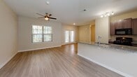 Located at 3340 Shipley St in Ladson, South Carolina, this single-story residence offers a thoughtfully designed layout with a bright, open-concept living and dining area. Light wood-look flooring flows throughout the main living spaces, complemented by a ceiling fan and large windows that invite abundant natural light. French doors in the living area provide additional brightness and outdoor access.

The kitchen is outfitted with dark espresso cabinetry, granite countertops, and black appliances including a range, built-in microwave, and refrigerator, all finished with a clean, functional aesthetic. A peninsula with a sink and granite surface connects the kitchen to the living area seamlessly.

Multiple bedrooms feature soft, neutral-toned carpet, ceiling fans, and windows with blinds that allow for natural light while maintaining privacy. Each bedroom includes closet access, offering practical storage solutions. The bathrooms are finished with granite-topped dark vanities, large mirrors, wood-look tile flooring, and tiled tub-shower combinations with chrome fixtures, delivering a consistent and polished look throughout. The overall color palette of warm beige and white tones creates a clean, cohesive ambiance across the entire residence.