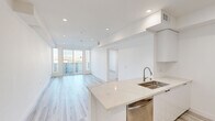 Located at 4808 Oakwood Ave in the heart of Los Angeles, this modern single-floor unit offers a clean, contemporary aesthetic defined by an all-white palette, light wood-look flooring, and recessed lighting throughout. The open-concept living and kitchen area forms the heart of the space, where a well-appointed kitchen features handle-free white cabinetry, a striking marble-look quartz island with a stainless steel sink, and a full suite of stainless steel appliances including a gas range, microwave, and refrigerator. The living area flows seamlessly toward a private balcony accessed through large sliding glass doors, allowing an abundance of natural light and open views of the surrounding neighborhood. A dedicated bedroom provides a quiet retreat, benefiting from corner windows that frame additional outdoor views and fill the room with daylight. The bathroom is finished to a high standard, featuring a quartz-topped vanity with an illuminated mirror, a soaking tub with tiled surround, and warm neutral tile flooring. Clean lines, bright white walls, and consistent modern finishes lend a cohesive, move-in-ready feel to this well-designed Los Angeles residence.