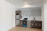 Located at 240 Mack Ave in Detroit's vibrant Midtown neighborhood, this efficiently designed unit offers a thoughtfully organized single-floor layout that maximizes every square foot. Light-toned hardwood-style flooring runs throughout, creating a cohesive and clean aesthetic across all living areas.

The combined dining and kitchen area is a standout feature, showcasing modern two-tone cabinetry with dark wood lower cabinets and light gray uppers, complemented by a crisp white countertop. Stainless steel appliances — including a refrigerator and dishwasher — along with a gas range and a sleek black-finish sink complete the well-equipped kitchen.

The living area flows naturally through an open archway into a secondary room distinguished by a bold navy accent wall and dual windows that invite natural light and views of the surrounding neighborhood. Recessed lighting and clean white walls throughout the unit contribute to a bright, contemporary ambiance.

The bathroom features classic white subway tile surrounding a full soaking tub and shower combination, offering a clean and timeless finish. Additional conveniences include a dedicated laundry area and two closets, providing practical storage solutions. This unit presents a polished, move-in-ready space with modern finishes in a prime Detroit location.