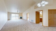 Located at 304 Nautical Drive in Sturgeon Bay, Wisconsin, this well-appointed single-story home offers 2 bedrooms, 3 bathrooms, and a thoughtfully designed layout. The spacious living room is a standout, featuring soaring vaulted ceilings, a ceiling fan, a corner fireplace with a wood-trimmed surround, and sliding glass doors that open to a private patio with neighborhood views. Plush wall-to-wall carpeting runs throughout the living areas and bedrooms, contributing to a warm, comfortable ambiance. The open kitchen is equipped with warm oak cabinetry, light countertops, a central island, tile flooring, and white appliances including a range, dishwasher, and refrigerator — all bathed in natural light from a window above the sink. The generously sized primary bedroom features vaulted ceilings, a ceiling fan, and access to a patio, while the second bedroom offers ample space and a large window with outdoor views. The three bathrooms are finished with tile flooring and oak vanities, and one bathroom conveniently incorporates a stacked washer and dryer. With four closets providing excellent storage, this home combines practical functionality with an airy, open feel throughout.