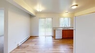 Located at 3428 W McLeod Rd in Marietta, WA, this single-floor residence offers a thoughtfully organized layout comprising one bedroom, one bathroom, a kitchen, and a connecting hallway. The kitchen is outfitted with warm honey-toned oak cabinetry, granite-look countertops, a stainless steel double sink, and a white electric range with overhead ventilation. Light wood-look flooring runs throughout the kitchen and extends into the adjacent living area, which benefits from generous natural light via large sliding glass doors and a window fitted with vertical blinds, offering views of the surrounding greenery. The bedroom provides a comfortable, carpeted retreat with neutral toned walls, a window that invites natural light, and a baseboard heating unit for year-round comfort. The bathroom is finished with warm oak vanity cabinetry, a granite-look countertop with an integrated sink, a large mirror, wood-look flooring, and a full bathtub and shower combination. A baseboard heater and overhead ventilation add practical functionality to the space. Throughout the residence, the consistent use of warm wood tones, neutral walls, and soft carpeting creates a cohesive and inviting atmosphere.