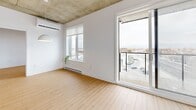 Located at 17 Rue Hyman in Dollard-Des-Ormeaux, this modern 3-bedroom, 2-bathroom unit offers a thoughtfully designed single-floor layout with a clean, contemporary aesthetic throughout. Light hardwood flooring runs seamlessly through the main living areas and bedrooms, complemented by crisp white walls that enhance the sense of brightness and openness.

The kitchen is a standout feature, showcasing warm wood cabinetry paired with white upper cabinets, a white quartz peninsula with bar seating, stainless steel appliances, and pendant lighting — combining both style and functionality. The adjacent living area benefits from an exposed concrete ceiling that adds an industrial character, along with a patio door leading to a private balcony overlooking city views.

The three bedrooms are bright and well-proportioned, each featuring hardwood floors, windows with outdoor views, and baseboard heating. The exposed concrete ceiling detail carries into the bedrooms, reinforcing the unit's modern industrial design.

The two bathrooms are finished in light tile with clean, minimalist fixtures. The main bathroom features a soaking tub with a glass shower panel, while the second bathroom offers a glass-enclosed walk-in shower and a wood-accented vanity with an undermount sink. A welcoming hallway connects all rooms, completing this well-appointed home.