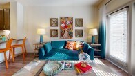 This single-floor residence showcases a thoughtfully designed layout that balances modern finishes with bold, eclectic style. The open-concept kitchen is a standout, outfitted with dark espresso cabinetry, granite countertops, a full suite of stainless steel appliances, a subway tile backsplash, and a peninsula with bar seating — all illuminated by pendant lighting and recessed fixtures. Rich hardwood-style flooring runs throughout the main living areas, adding warmth and continuity to the space.

The living area is bright and welcoming, benefiting from natural light that filters through large windows dressed with ombre curtains. The space offers a comfortable and stylish setting with neutral walls that serve as a canvas for vibrant décor.

The bedrooms are carpeted and generously sized, each featuring large windows that invite natural light and views of the outdoors. Ceiling fans add practicality, while the rooms' layouts comfortably accommodate full furniture arrangements.

The bathroom is elegantly appointed with a dual-sink vanity topped with granite countertops, dark cabinetry with brushed nickel hardware, and hardwood-style flooring accented by a colorful runner rug. A spacious walk-in closet with built-in shelving and hanging rods connects directly to the bathroom, providing ample storage and everyday convenience.