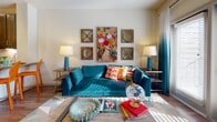 This single-floor residence showcases a thoughtfully designed layout that balances modern finishes with bold, eclectic style. The open-concept kitchen is a standout, outfitted with dark espresso cabinetry, granite countertops, a full suite of stainless steel appliances, a subway tile backsplash, and a peninsula with bar seating — all illuminated by pendant lighting and recessed fixtures. Rich hardwood-style flooring runs throughout the main living areas, adding warmth and continuity to the space.

The living area is bright and welcoming, benefiting from natural light that filters through large windows dressed with ombre curtains. The space offers a comfortable and stylish setting with neutral walls that serve as a canvas for vibrant décor.

The bedrooms are carpeted and generously sized, each featuring large windows that invite natural light and views of the outdoors. Ceiling fans add practicality, while the rooms' layouts comfortably accommodate full furniture arrangements.

The bathroom is elegantly appointed with a dual-sink vanity topped with granite countertops, dark cabinetry with brushed nickel hardware, and hardwood-style flooring accented by a colorful runner rug. A spacious walk-in closet with built-in shelving and hanging rods connects directly to the bathroom, providing ample storage and everyday convenience.
