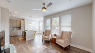 Located in Charlotte's 28277 zip code, this well-appointed 2-bedroom, 3-bathroom single-floor home offers a thoughtfully designed open-concept layout that seamlessly connects the living room, dining area, and kitchen. The living space is bathed in natural light through large windows dressed with white blinds, complemented by wood-look flooring and a ceiling fan overhead.

The kitchen is a standout feature, showcasing light wood cabinetry, granite countertops with a subtle veining pattern, a tile backsplash, stainless steel appliances, and an island with seating — ideal for casual dining. Pendant lighting adds a refined touch above the island.

Each of the three bathrooms features warm wood-toned vanities, granite countertops, and framed mirrors with modern lighting fixtures. The primary bath includes a double vanity with ample drawer storage, while a secondary bath offers a full-height storage tower for added functionality.

The bedrooms are carpeted and filled with natural light, each with ceiling fans and generous closet space. The walk-in closet impresses with built-in shelving and hanging rods on three walls. Additional highlights include four closets throughout, an in-unit laundry area, and a private balcony — rounding out a practical and polished living experience.