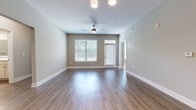 Located at 11240 Woolwich St in Charlotte, NC, this single-story, 3-bedroom, 2-bathroom home offers a thoughtfully designed layout with modern finishes throughout. The open-concept living room features rich hardwood-style flooring, a ceiling fan, and large windows with blinds that invite generous natural light and views of the surrounding greenery. The kitchen is a standout, equipped with light wood cabinetry reaching near the ceiling, granite countertops, a classic white subway tile backsplash, black appliances including a refrigerator, range, microwave, and dishwasher, and a stylish pendant chandelier. The bedrooms are carpeted for comfort, with the primary bedroom offering a walk-in closet outfitted with wire shelving and hanging rods. The bathrooms are finished with wood-look flooring, white vanity cabinetry, and a tiled walk-in shower with sliding glass doors. A dedicated laundry room accommodates a full-size washer and dryer. Neutral gray-toned walls and consistent flooring create a cohesive, modern aesthetic throughout the home, making it a functional and attractive residence.