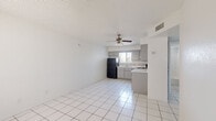 Located on W Camelback Rd in Phoenix, AZ, this single-story, 2-bedroom, 1-bathroom home offers a practical and functional layout. The open living and kitchen area features white large-format tile flooring and a ceiling fan with light fixture, creating a bright and airy atmosphere. The kitchen is well-equipped with gray cabinetry, tile backsplash, white countertops, and black appliances including a refrigerator, electric range, and dishwasher, along with a window with vertical blinds that brings in natural light.

Both bedrooms are carpeted and feature textured ceilings, windows with vertical blinds, and ample wall space. The primary bedroom includes a built-in closet, providing convenient storage. The second bedroom also benefits from a window with outdoor views of surrounding greenery.

The bathroom is clean and straightforward, featuring tile flooring, a full tub-shower combo, a gray vanity with a countertop, and a small window for natural ventilation. A hallway connects the main areas of the home efficiently. Throughout the space, the consistent white walls and neutral tones create a cohesive, easy-to-personalize environment suitable for a variety of living arrangements.