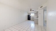 Located on W Camelback Rd in Phoenix, AZ, this single-story, 2-bedroom, 1-bathroom home offers a practical and functional layout. The open living and kitchen area features white large-format tile flooring and a ceiling fan with light fixture, creating a bright and airy atmosphere. The kitchen is well-equipped with gray cabinetry, tile backsplash, white countertops, and black appliances including a refrigerator, electric range, and dishwasher, along with a window with vertical blinds that brings in natural light.

Both bedrooms are carpeted and feature textured ceilings, windows with vertical blinds, and ample wall space. The primary bedroom includes a built-in closet, providing convenient storage. The second bedroom also benefits from a window with outdoor views of surrounding greenery.

The bathroom is clean and straightforward, featuring tile flooring, a full tub-shower combo, a gray vanity with a countertop, and a small window for natural ventilation. A hallway connects the main areas of the home efficiently. Throughout the space, the consistent white walls and neutral tones create a cohesive, easy-to-personalize environment suitable for a variety of living arrangements.