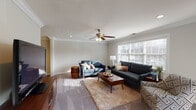 Located at Fairfield Knolls in Sayville, NY, this single-floor residence delivers a refined living experience with consistent, quality finishes across every room. The bright and spacious living room is a standout feature, showcasing elegant crown molding, plush carpeting, a ceiling fan with light fixture, and large windows dressed with plantation shutters that invite an abundance of natural light and views of the surrounding landscape. The dining area is distinguished by rich dark tile flooring, crisp crown molding, a decorative chandelier, and columned architectural detailing that adds a formal, classic character. The kitchen impresses with rich cherry wood cabinetry, sleek black granite countertops, a coordinating tile backsplash, stainless steel appliances, and glass-front upper cabinets — a combination that creates a warm yet sophisticated culinary space. The bedroom is generously proportioned, featuring soft carpeting, crown molding, a ceiling fan, and a well-organized built-in closet system with adjustable shelving and pull-out drawers for practical storage. The bathroom is neatly finished with a glass-enclosed shower and tub combination, dark granite vanity countertop, tile wainscoting with a decorative border accent, and a large mirror. Carpeted stairs connect levels within the home, completing this well-designed and move-in-ready residence.