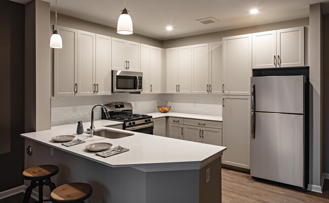 Modern kitchens with grey cabinetry, white quartz countertops, tile backsplash, stainless steel appliances, and hard surface flooring - Avalon Boonton