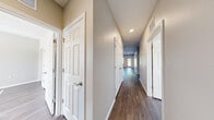 Located at 6646 Westbrook Cir in Weeki Wachee, FL, this single-story home offers five bedrooms and two full bathrooms across a thoughtfully designed floor plan. Rich wood-look flooring runs throughout the entire home, providing a cohesive and contemporary aesthetic.

The open-concept living and kitchen area serves as the heart of the home, filled with natural light from multiple windows. The kitchen is well-appointed with rich dark wood cabinetry, granite countertops, a full suite of stainless steel appliances including a refrigerator, range, and microwave, and a central island with a built-in sink — ideal for both cooking and casual dining. A ceiling fan overhead adds comfort to the spacious living area.

A long hallway connects the five bedrooms, each featuring wood-look flooring, neutral-toned walls, and windows that allow natural light to filter in. The primary bedroom offers a generous footprint along with a walk-in closet equipped with a full-width hanging rod. Additional bedrooms are well-sized and versatile.

The bathrooms are finished with granite-topped dark wood vanities and tub-shower combinations. Recessed lighting and clean, neutral finishes carry a consistent modern style throughout the home, making it a functional and comfortable residence.
